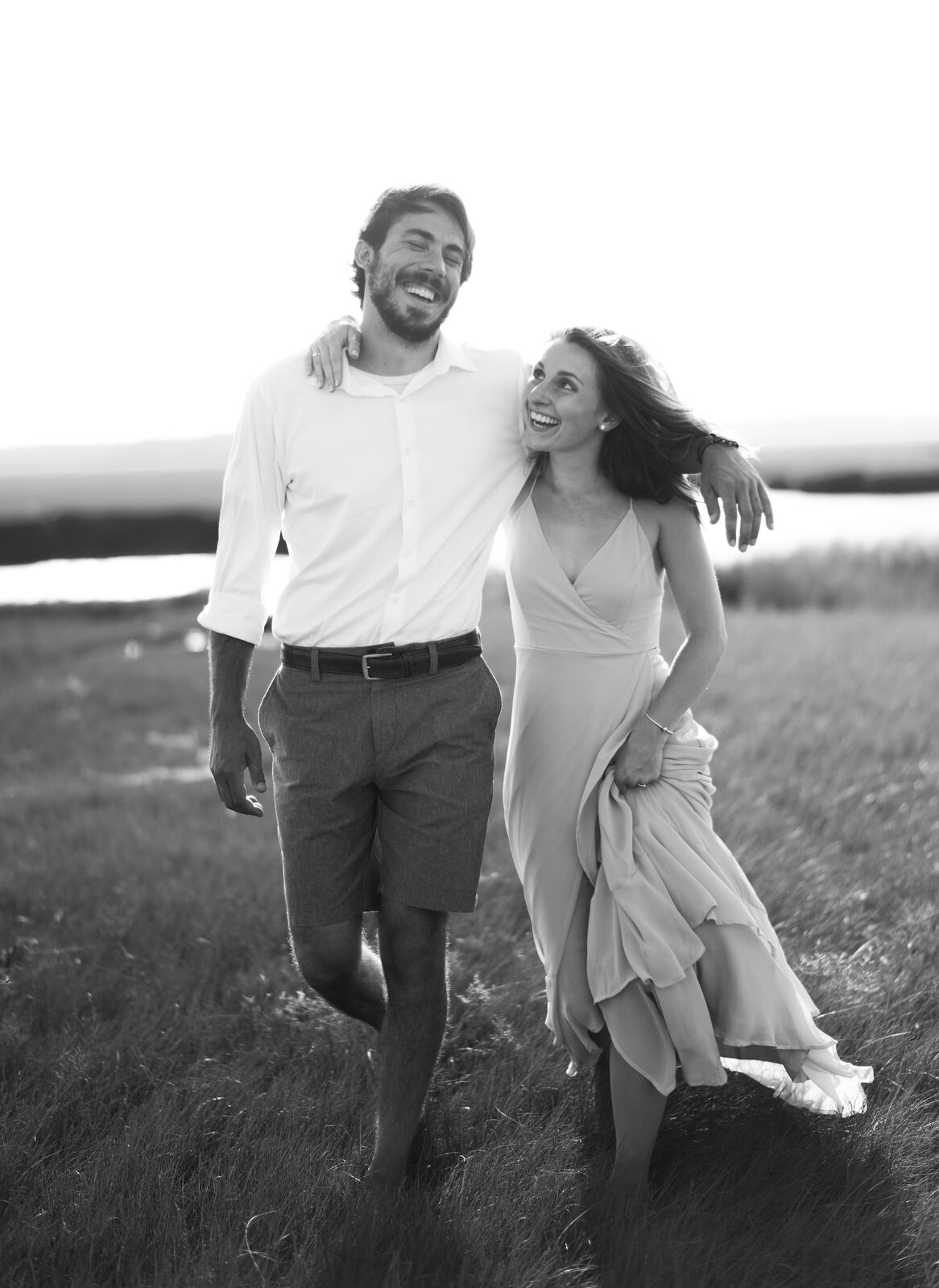 Couple walking hand in hand near the water, black and white